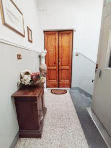 um corredor com uma porta e uma mesa com flores em FLORENCE ROOFTOP RETREAT em Florença