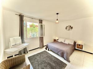 a bedroom with a bed and a desk and a window at Residence Canella in Sari Solenzara +94 photos