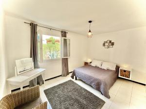 - une chambre avec un lit, un bureau et une fenêtre dans l'établissement Residence Canella, à Sari-Solenzara