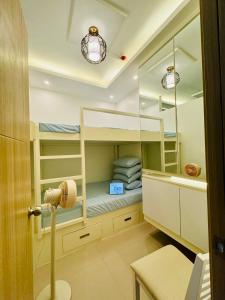 a small room with bunk beds and a table at SMDC Vine Residences Condo in Manila