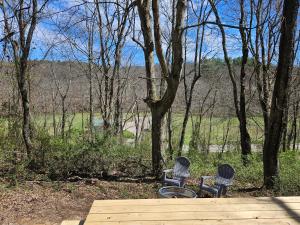 two chairs sitting on a wooden deck in the woods at Black Oak Campsite at Hocking Vacations Campsites - Tent not Included in Logan