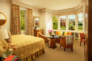 BenderlochにあるIsle of Eriska Hotel Spa & Islandのベッドルーム1室(ベッド1台、テーブル、ソファ付)