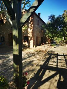 an outside view of a building with the shadow of a fence at Le mas petit in Thuir