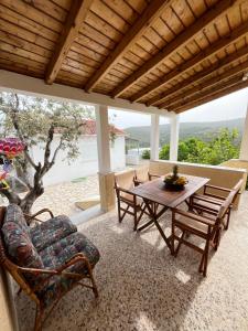 a patio with a wooden table and chairs on a porch at Rustic and Spacious House in Mytilinioí
