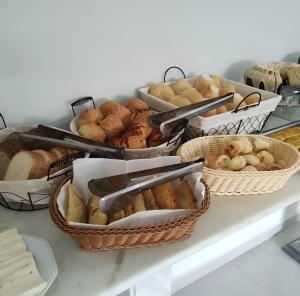 a bunch of baskets of bread and pastries on a counter at Hotel Penedo Inn in Penedo