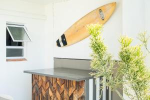 a surfboard hanging on a wall next to a table at Villa 43, The Estuary Country Estate, Port Edward, KZN South Coast in Port Edward