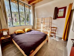 - une chambre avec un lit dans une pièce dotée de fenêtres dans l'établissement L'atelier du Salagou, à Octon