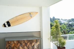a surfboard hanging on a wall next to a window at Villa 43, The Estuary Country Estate, Port Edward, KZN South Coast in Port Edward