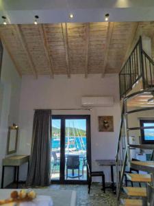 a room with a staircase and a view of a boat at Villa Don Kostangelo in Nikiana
