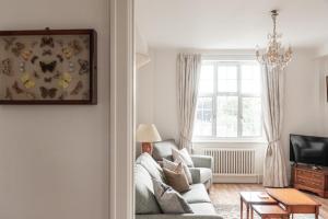 a living room with a couch and a window at Chestnut Blossom - 1 Bedroom in Kensington in London
