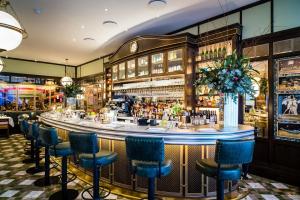 a bar at a restaurant with blue chairs at Chestnut Blossom - 1 Bedroom in Kensington in London