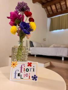 a vase of flowers sitting on a table with a sign at B&B Relais Druda in Cagli