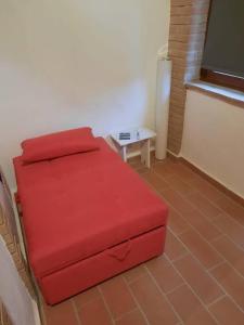 a red bed in a room with a table at Il giardino fiorito in Santa Luce +24 photos