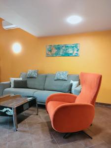 un salon avec un canapé et une chaise dans l'établissement La magnanerie colorée. (5 personnes, 3 chambres), à Ancône