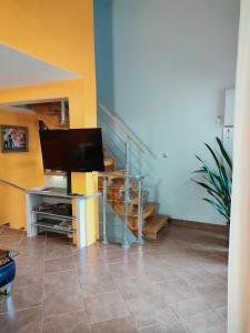 - un salon avec une télévision et un escalier dans l'établissement La magnanerie colorée. (5 personnes, 3 chambres), à Ancône