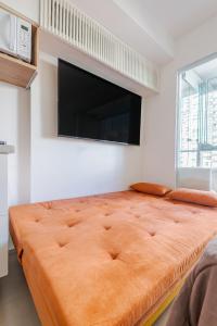 een slaapkamer met een groot bed en een flatscreen-tv bij Apartamento novo e completo próximo a paulista in Sao Paulo