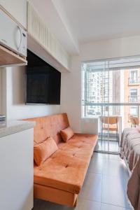 een woonkamer met een bank en een tv bij Apartamento novo e completo próximo a paulista in Sao Paulo