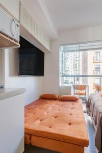 een groot bed in een kamer met een groot raam bij Apartamento novo e completo próximo a paulista in Sao Paulo