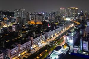 a city lit up at night with traffic at "GRAND OPENED" Maxtyle Guesthouse Dongdaemun in Seoul