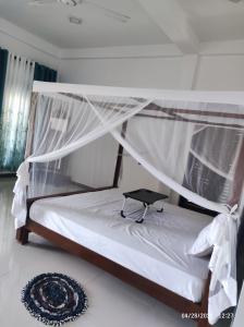 ein weißes Bett mit Baldachin in einem Zimmer in der Unterkunft Star Mantion in Tangalle