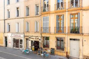 a building with tables and chairs on a city street at Studio standing plein centre Aix in Aix-en-Provence