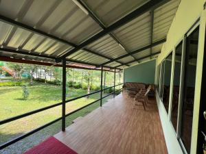 een afgeschermde veranda van een huis met een terras bij The Midway Jungle Resort in Masinagudi
