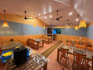 una sala da pranzo vuota con tavoli e sedie di The Midway Jungle Resort a Masinagudi