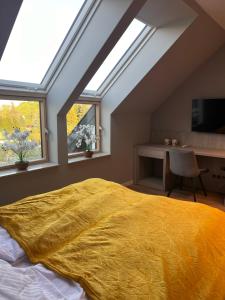 1 dormitorio con 1 cama con manta amarilla en Willa Olimpia, en Podzamcze
