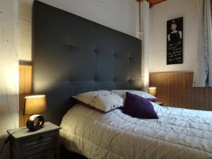 een slaapkamer met een groot bed met een blauw hoofdeinde bij La Méridienne - Gite Ceusette in Venterol