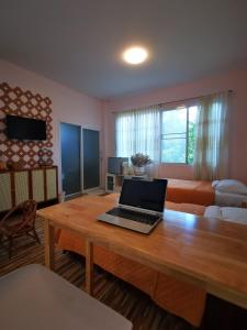 宋卡的住宿－SN Garden，客厅配有一张木制桌子上的笔记本电脑