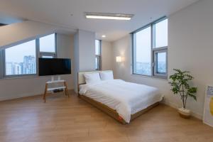 ソウルにある"GRAND OPENED" Maxtyle Guesthouse Dongdaemunのベッドルーム(ベッド1台、薄型テレビ付)