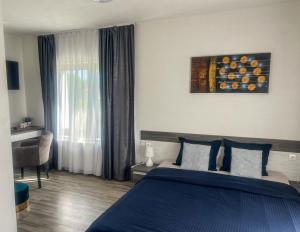 sypialnia z niebieskim łóżkiem i oknem w obiekcie Guest House Klanfar w mieście Grabovac