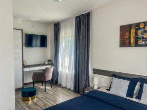 a bedroom with a bed and a desk and a window at Guest House Klanfar in Grabovac
