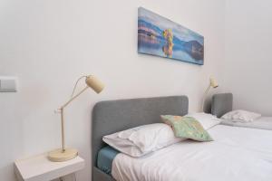 ein Schlafzimmer mit einem Bett mit einer Lampe und einem Bild an der Wand in der Unterkunft BLife Salinya private rooms in Olhão