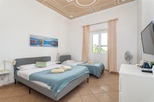 1 Schlafzimmer mit 2 Betten, einem TV und einem Fenster in der Unterkunft BLife Salinya private rooms in Olhão