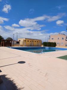 een leeg zwembad met gebouwen op de achtergrond bij Reina Victoria 2 bed apartment in Rojales