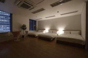 um quarto com 2 camas, uma mesa e uma janela em "GRAND OPENED" Maxtyle Guesthouse Dongdaemun em Seul