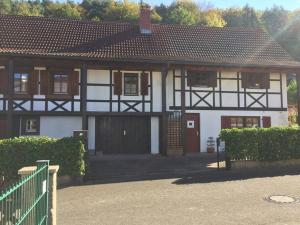 a white house with a gate and a fence at Ferienwohnung am Maimont in Gebüg