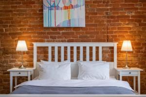 ein Schlafzimmer mit einem weißen Bett mit zwei Nachttischen und zwei Lampen in der Unterkunft Danylo Inn in Lwiw