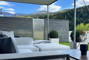 a patio with two white couches and a view of the mountains at WEITBLICK "entspannen - wohlfühlen - aktiv erholen" in Elzach