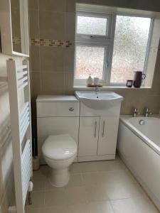 ein Badezimmer mit einem WC, einem Waschbecken und einer Badewanne in der Unterkunft Cosy home close to M6 motorway in Pemberton