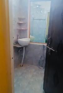 La salle de bains est pourvue d'un lavabo, de toilettes et d'un miroir. dans l'établissement Pretty park facing 2 bedroom guesthouse near lohia park Gomtinagar, à Lucknow