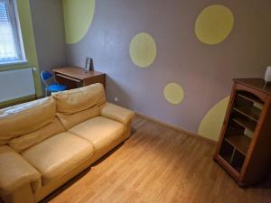 sala de estar con sofá y círculos amarillos en la pared en Appartement dans Maison en pleine campagne, en Métairies-Saint-Quirin