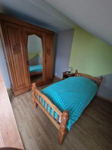1 dormitorio con cama de madera y espejo en Appartement dans Maison en pleine campagne, en Métairies-Saint-Quirin