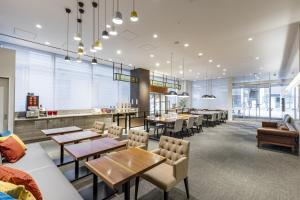 een restaurant met tafels en stoelen en een bar bij Tokyu Stay Suidobashi in Tokyo
