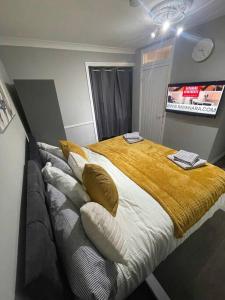 - une chambre avec un lit doté de draps et d'oreillers jaunes dans l'établissement The Lodge on Lodge Road (Rayanara), à Southampton