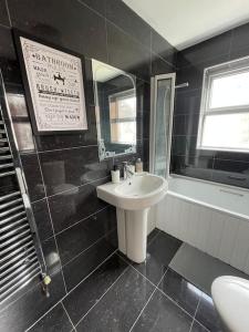 - une salle de bains en noir et blanc avec lavabo et miroir dans l'établissement The Lodge on Lodge Road (Rayanara), à Southampton