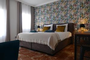 ミハスにあるVilla Mañanaの花柄の壁紙を用いたベッドルーム1室(大型ベッド1台付)