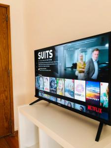 a flat screen tv sitting on top of a table at Quarto Duplo em Lisboa - Casa de Anfitrião in Lisbon