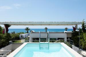 a swimming pool on the roof of a house with the ocean at Boutique Hotel Esplanade in Paestum
